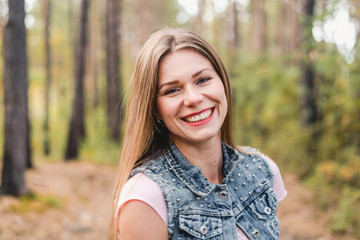 Obraz premium Young woman outdoors in park on sunny autumn day