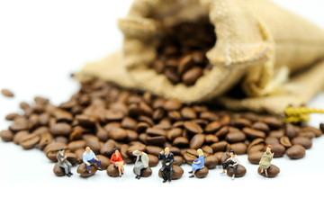 Miniature people : people sitting on Roasted coffee beans using for concept of Cappuccino Day.
