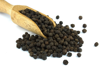 Black pepper on wooden scoop isolated on white background