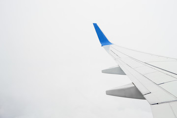 View on airplane wing in the cloudy sky during the flight. Overcast consept, bad visibility.
