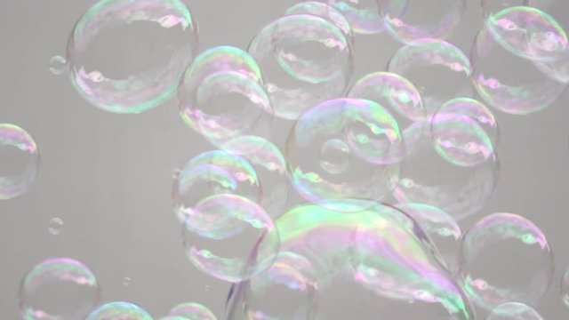 Abstract white background with soap bubbles, pubblic entertainment. Slow motion