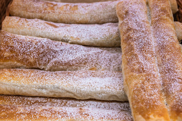 Baking, oblong bread sprinkled with white powder.