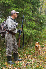 hunter with a dog beckons grouse
