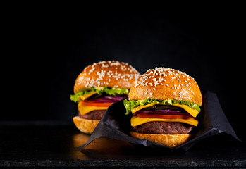 Beef burgers or cheeseburgers in black paper