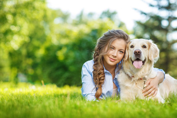 Young woman with golden retriever dog in the summer park