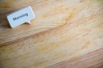 Word “Morning” white button on wood texture background in the left corner with space for add text, copy space and template. use to template for meeting and  presentation. reminder concept with space.