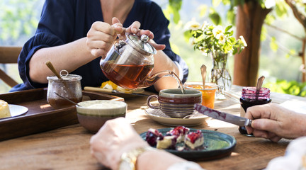 Daughter pouring hot tea for mother - obrazy, fototapety, plakaty