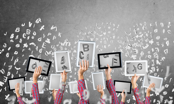 Close of woman hands in line showing tablet pc against concrete wall