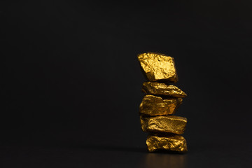 A pile of gold nuggets or gold ore on black background, precious stone or lump of golden stone,...
