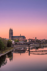 Colorful sunset in front of cathedral and old bridge in Magdeburg, Germany - obrazy, fototapety, plakaty