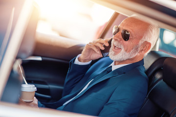 Senior businessman with phone in car - obrazy, fototapety, plakaty