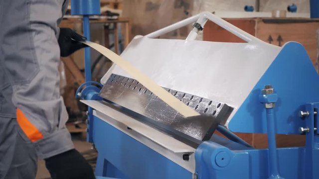 manufacture workshop. Workers adjusts the machine in the warehouse. the production of ventilation and gutters. Tool and bending equipment for sheet metal.