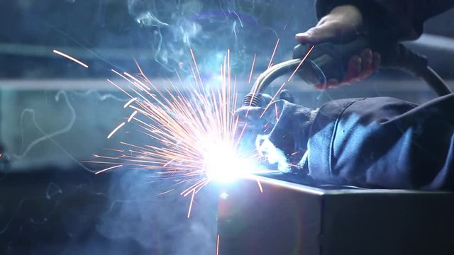 Welding of the safe. Electric welding of the safe. Sparks fly. Working room. Natural lighting.