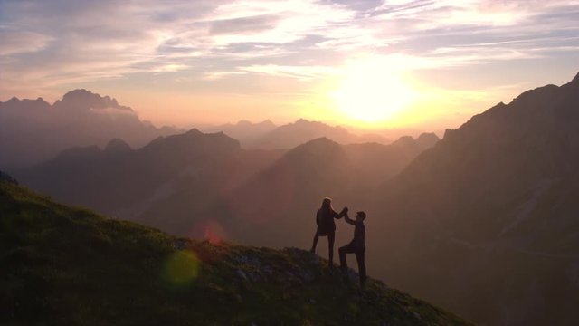 Aerial - Silhouette of a couple giving each other a high five celebrating succes