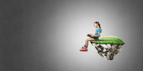 Naklejka premium Concept of careless happy childhood with girl reading book
