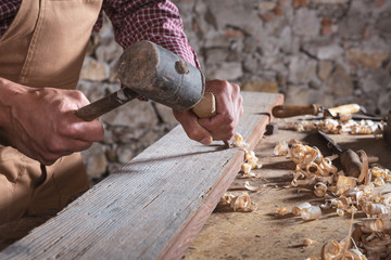 Woodworker using chisel to smooth down wood