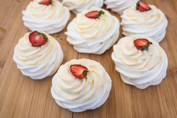 White cakes with strawberries on top.