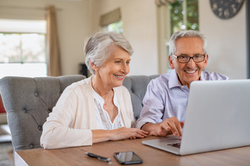 Senior couple using laptop - obrazy, fototapety, plakaty