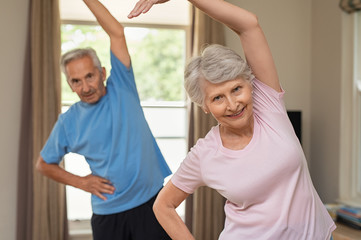 Senior couple doing stretching exercise - obrazy, fototapety, plakaty