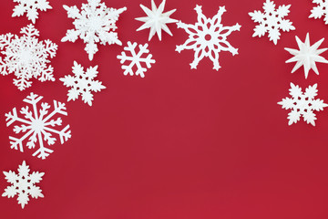 Naklejka na ściany i meble White snowflake bauble decorations forming a Christmas background border on red. Traditional Christmas greeting card for the festive holiday season.
