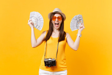 Tourist woman in summer casual clothes, hat holding bundle lots of dollars, cash money isolated on...