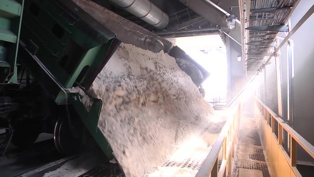 Self-unloading wagon for bulk materials.  Rail freight wagons with sand. Railway wagon loaded with sand.