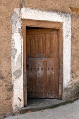 Old rusty wooden door, open to dark entrance