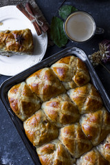 Hot cross buns with the cup of coffee, cinnamon sticks on the table flat lay