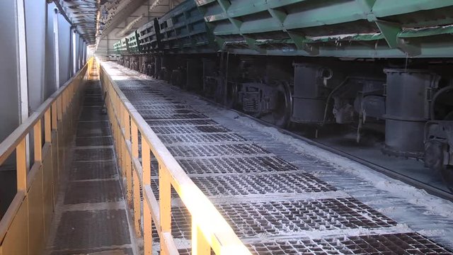 Self-unloading wagon for bulk materials.  Rail freight wagons with sand. Railway wagon loaded with sand.