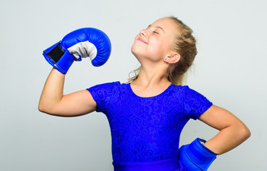 Naklejka premium Upbringing for leadership and winner. Feminist movement. Strong child proud winner boxing competition. Girl child happy winner with boxing gloves posing on grey background. She feels as winner