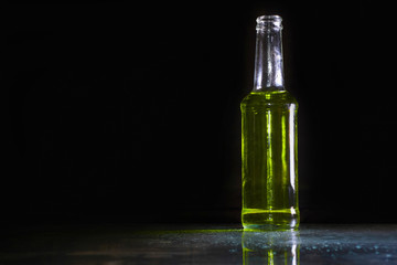 Cocktail yellow drink in bottle cold on the table / selective focus / Dark style and category drink food / on black background isolated