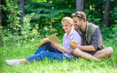 Fototapeta premium Romantic date at green meadow. Couple in love spend leisure reading book. Romantic couple students enjoy leisure with poetry nature background. Couple soulmates at romantic date. Pleasant weekend