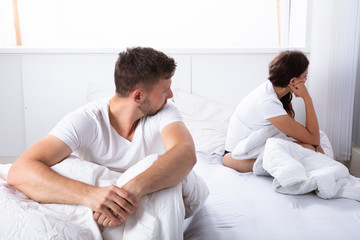 Obraz premium Unhappy Couple Sitting On Bed