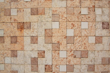 Wall of square marble plates of different colors red white and pink