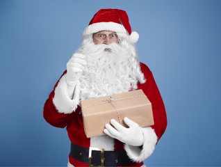 Surprised santa claus opening gift