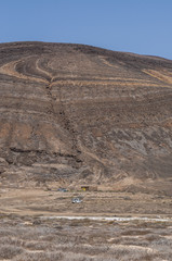 Lanzarote, Isole Canarie: strada sterrata, cespugli e paesaggio desertico con la Montagna Pedro Barba, il vulcano dell'isola La Graciosa