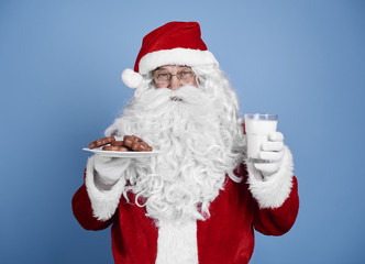 Santa claus with cookie and milk at studio shot