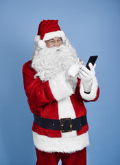 Santa claus using mobile phone at studio shot