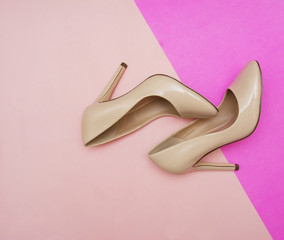 Beige high heel shoes on pink 