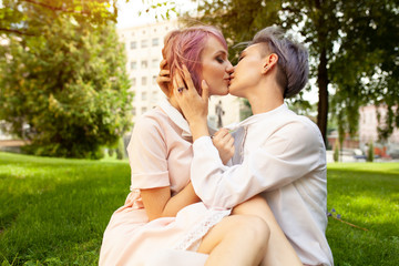 Naklejka premium Happy playful lesbian couple in love sharing time together Women friendship concept with girls couple having fun on fashion clothes outdoors Summertime leisure.