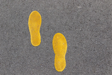 foot sign painted on asphalt