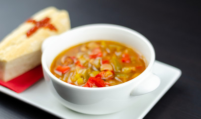 A delicious stew in a white ceramic bowl served with bread in the shape of a coffin