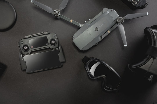 Work space professional photographer flight kit on quadcopter with VR glasses. Top view on black table background. Concept of mockup template.