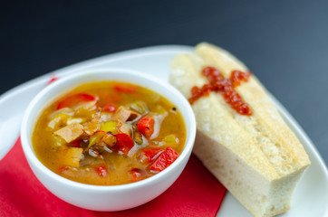 A delicious stew in a white ceramic bowl served with bread in the shape of a coffin