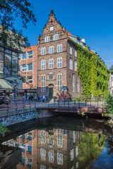 Naklejka premium GDANSK, POLAND - SEPTEMBER 1, 2016: Reflection of a brick house in a canal in Gdansk, Poland
