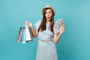 Portrait young woman in summer dress, straw hat holding packages bags with purchases after...