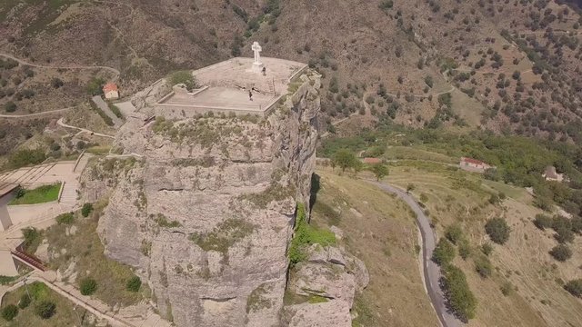 Stunning orbit 4k aerial of rock with Catholic cross in Bova, Calabria, Italy