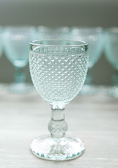 Empty glasses for drinks stand on a wooden white background. View from front. Colors are blue.