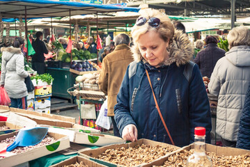 Beautiful blonde middle-aged woman, buys groceries at the market, fruit and vegetables