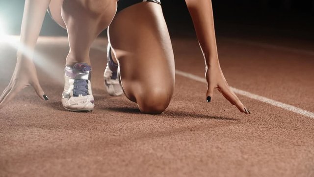 Asian Athlete ready to start. Young female runner preparing for blasting off in mist on sports track of stadium, training before competition 4k